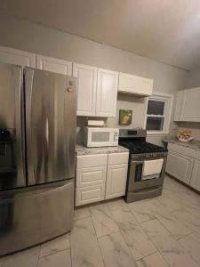 una cocina con nevera de acero inoxidable y armarios blancos en Suite Dream Clifton 27, en Clifton