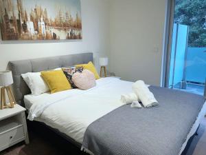a bedroom with a bed with yellow and white pillows at Chic Short Stay Retreat at Doncaster in Doncaster