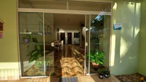 a hallway with glass doors and potted plants at Pousada Executiva SolRiso Aeroporto Florianópolis in Florianópolis