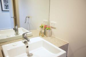 a bathroom with a white sink and a mirror at Chic Short Stay Retreat at Doncaster in Doncaster