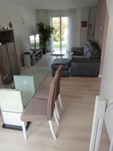 ein Wohnzimmer mit einem Glastisch und einer Couch in der Unterkunft Belle maison avec 3 chambres et jardin in Itteville