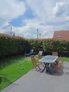 einen Tisch und 4 Stühle mit einem Tisch und einem Tisch in der Unterkunft Belle maison avec 3 chambres et jardin in Itteville + 3 Fotos