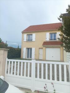 ein weißer Zaun vor einem Haus in der Unterkunft Belle maison avec 3 chambres et jardin in Itteville