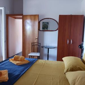 a bedroom with a bed with blue sheets and a table at Apartments Elena & Damir in Vis