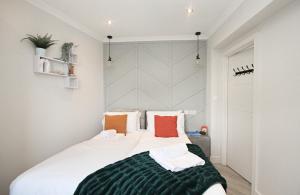 a bedroom with a large white bed with orange pillows at Rayan Heights Cosy 1 bedroom flat sleeps 2 perfect for contractors tourists families - Free parking in London