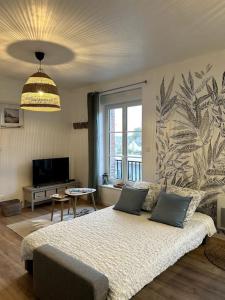 a living room with a bed and a large window at Appartement de la plage in Barneville-Carteret