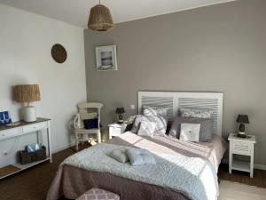 a bedroom with a large bed and two night stands at Appartement de la plage in Barneville-Carteret