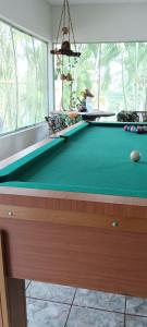 a pool table in a room with a window at Chácara Pingo de Ouro in Salto Grande