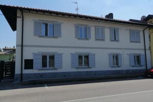a white building with blue shutters on it at La luna Blu Malpensa appartamento Lago in Somma Lombardo