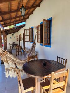 ein Esszimmer mit einem Tisch, Stühlen und einer Hängematte in der Unterkunft Brisa da Serra Hotel Pousada Pirenopolis in Pirenópolis