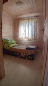 a small room with a bed and a window at Zacisze in Sarbinowo