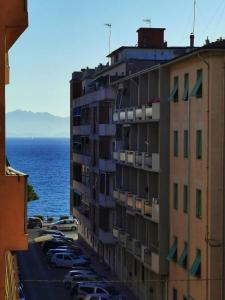 Un edificio alto con coches aparcados junto al océano. en La Casa di Lapo, en Piombino