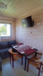 a living room with a table and a tv on a wall at Zacisze in Sarbinowo