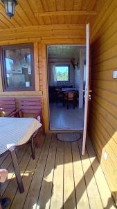 a porch of a cabin with a table and a dining room at Zacisze in Sarbinowo