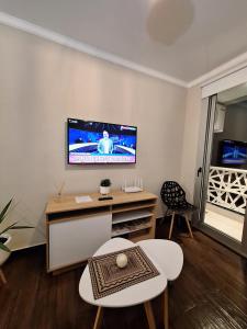uma sala de estar com uma televisão de ecrã plano na parede em BE ONE III IRIGOYEN - EXCELENTE DEPARTAMENTO A ESTRENAR MODERNO, UBICADO EN EL CORAZON DEL CAMBA CUA em Corrientes