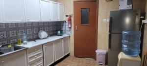 Mollah في أبوظبي: مطبخ مع دواليب بيضاء وثلاجة
