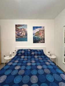 una camera con un letto blu con due tavoli di IN via venti a La Spezia