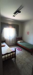 1 dormitorio con 2 camas y ventana en Chácara Pingo de Ouro en Salto Grande
