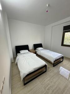 two beds in a room with white walls at New Apartment in Nablus City in Mashabbe Sade