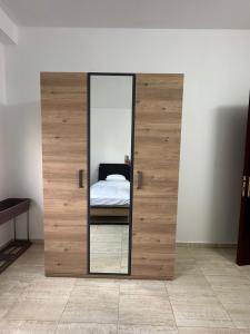 a bedroom with a large wooden door with a mirror at New Apartment in Nablus City in Mashabbe Sade