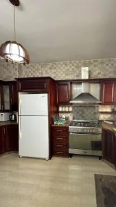 a kitchen with a white refrigerator and a stove at New Apartment in Nablus City in Mashabbe Sade