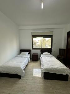 three beds in a room with a window at New Apartment in Nablus City in Mashabbe Sade