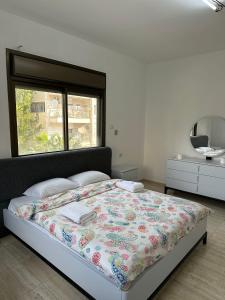 a bedroom with a bed and a window and a mirror at New Apartment in Nablus City in Mashabbe Sade