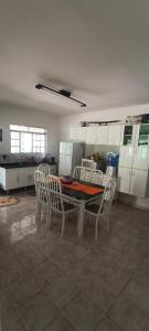 a kitchen with a table and chairs in a room at Chácara Pingo de Ouro in Salto Grande