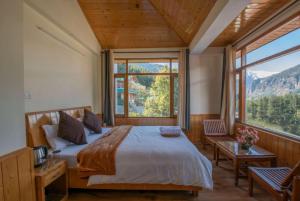 a bedroom with a bed and a large window at Goroomgo Urban Monk Stays, Manali in Manāli