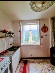 eine Küche mit einem Fenster mit Blick auf einen Turm in der Unterkunft La Casa Di Edy in Borzonasca