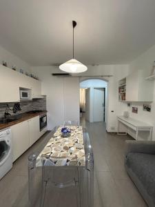 una cucina e un soggiorno con tavolo in vetro di IN via venti a La Spezia