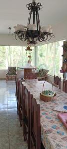 una sala da pranzo con tavolo, sedie e lampadario pendente di Chácara Pingo de Ouro a Salto Grande