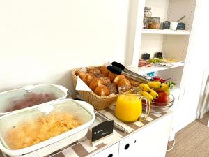 a kitchen counter with breakfast foods and orange juice at Hotel Villa Klasen in Wenningstedt