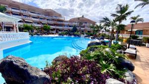 a swimming pool in a hotel with a resort at Boho Chic on the Beach by Deihu Experiences in Playa de las Americas