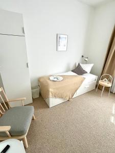 um pequeno quarto com uma cama e uma cadeira em Hotel Villa Klasen em Wenningstedt