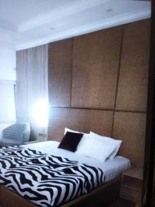 um quarto com uma cama com uma cabeceira com estampa de zebra em N.V HOTEL AND RESORT BEACH view em Lagos