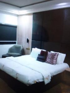 1 dormitorio con 1 cama blanca grande con almohadas en N.V HOTEL AND RESORT BEACH view, en Lagos