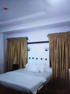 a bedroom with a white bed with curtains and avertisement at N.V HOTEL AND RESORT BEACH view in Lagos