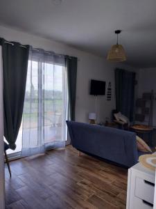 a living room with a couch and a large window at la petite maison in Lablachère