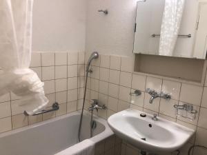 y baño con lavabo, bañera y espejo. en Cozy, sunny, city center 1 bedroom flat (Marble 3) en Zúrich