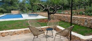 a patio with two chairs and a table and a pool at Bergerie provençale in Ampus