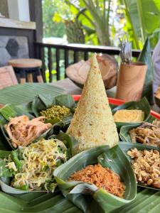 a table topped with plates of food on top at Widya Luxury House in Ubud