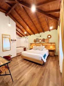 - une chambre avec un grand lit et un plafond en bois dans l'établissement Sie Casa Hotel, à Villa de Leyva