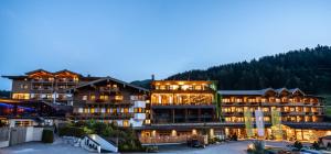 a large building with lights on in a ski resort at Hotel Riederalm in Leogang