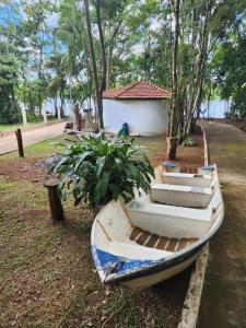 a boat sitting on the grass next to a tree at Chácara Pingo de Ouro in Salto Grande