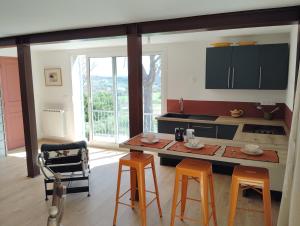 een keuken met een tafel, 2 stoelen en een aanrecht bij Loft rez de jardin in Forcalquier