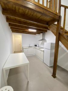 uma cozinha com electrodomésticos brancos e um tecto de madeira em Estudio Deluxe Hercules em Sevilha