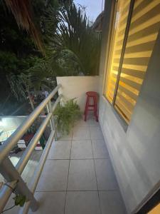 a red stool sitting on the porch of a house at Home's Jungle 15 Minutes from the Airport in Cancún