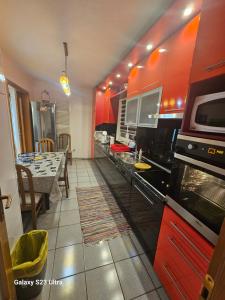 a kitchen with red cabinets and a dining room at Villa Kasinda in Sarajevo
