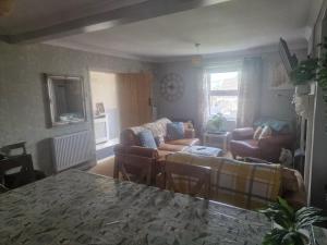 a living room with two couches and a table at Cosy 3-Bed House in Kidwelly in Kidwelly